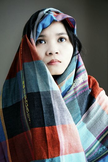 Young woman looking away against gray background