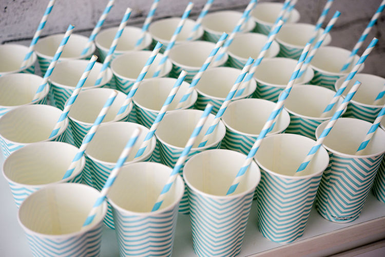 Close-up of disposable cups with striped drinking straws