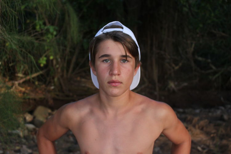 Portrait of teenage boy standing at lakeshore