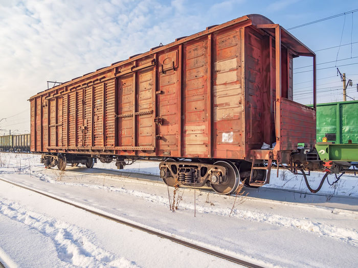 Red old, worn out boxcar of standard design on the rails on trans-siberian railway.