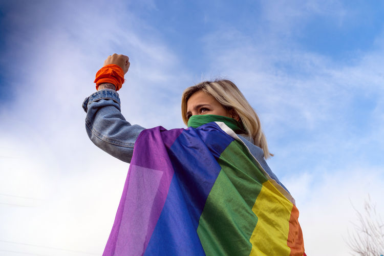 Young woman with ee diversity flag on her back turning to camera