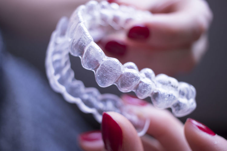 Cropped hand of woman holding artificial teeth