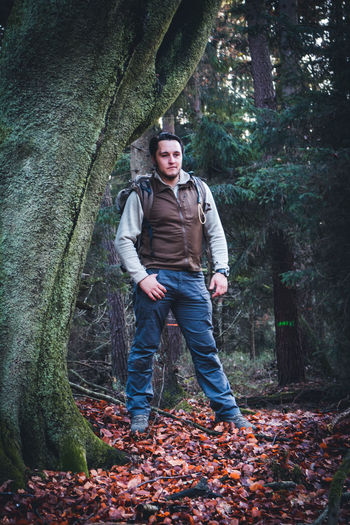 Portrait of backpacker standing in forest