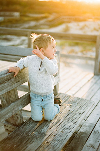 Boy looking away while wooden wood