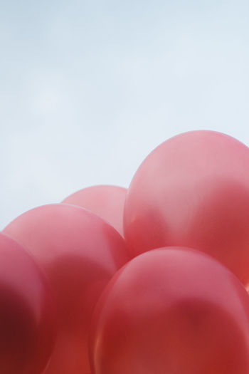 Low angle view of pink balloons against sky