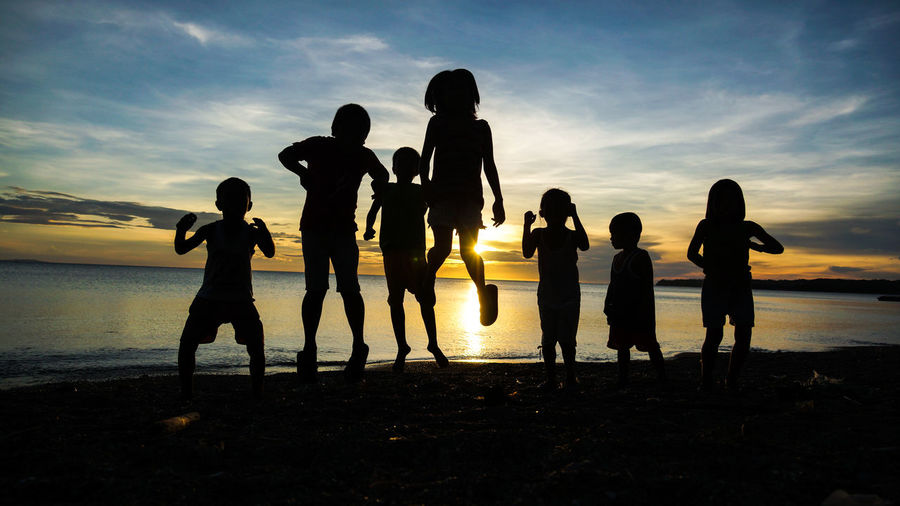 Silhouette of children on beach at sunset