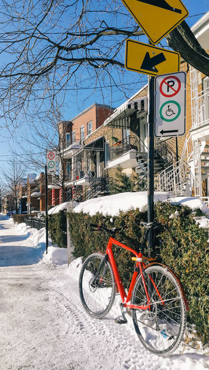 Bicycle on road by building during winter
