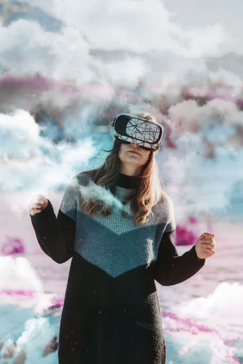 Woman with vr goggles outdoors in surreal world enjoying vr experience