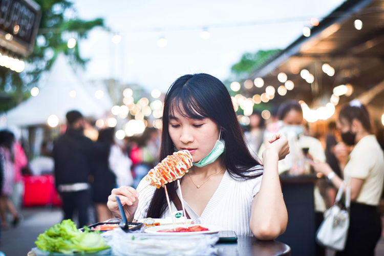 Portrait of woman eating food at restaurant