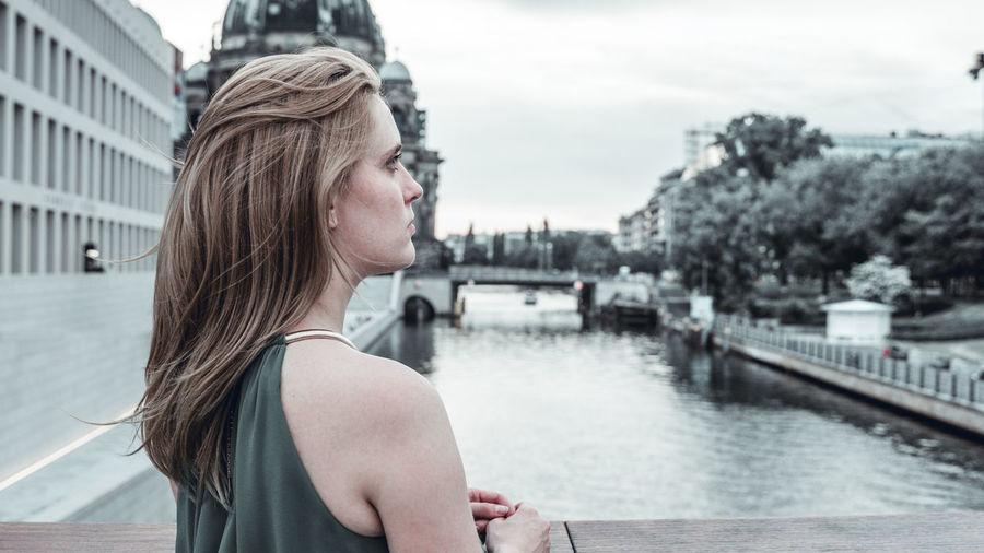 Beautiful young woman on bridge over river spree in berlin