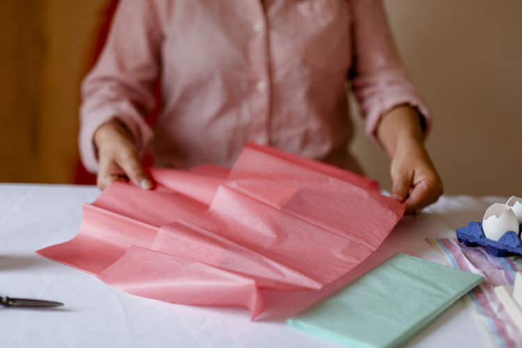 Midsection of woman holding paper