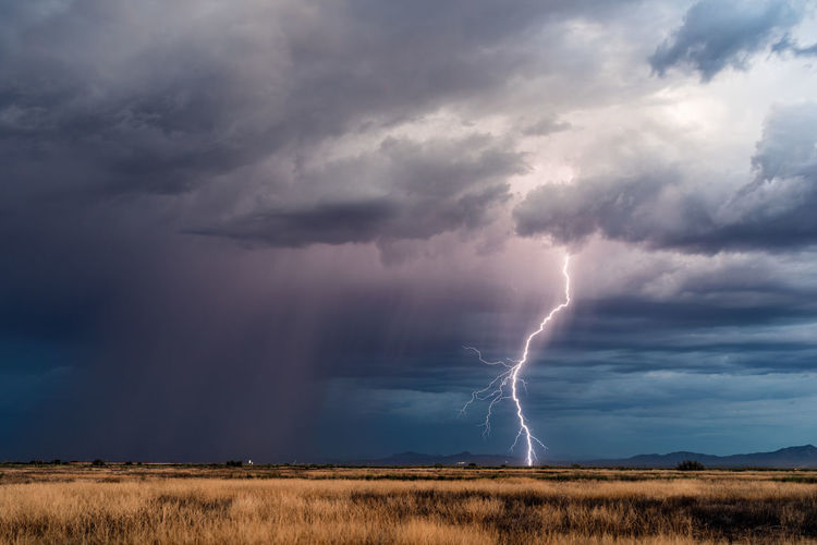 A powerful lightning bolt strikes ahead of a strong thunderstorm near douglas, arizona.