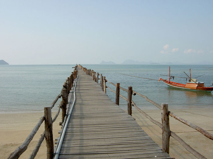 View of pier on calm sea against clear sky