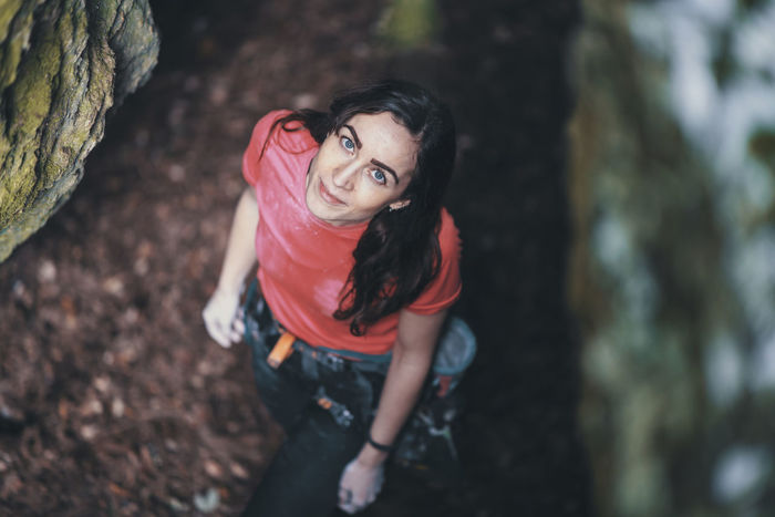 High angle portrait of smiling young woman standing in forest