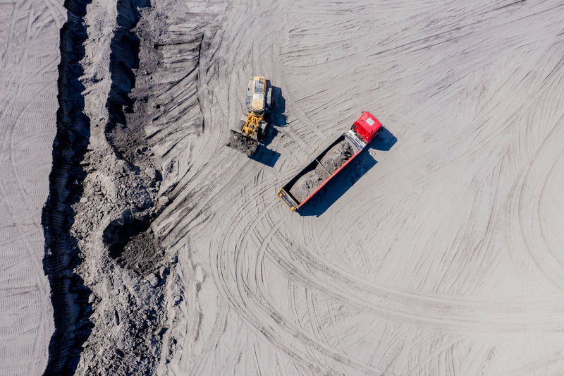 Aerial view of sand quarry with trucks and bulldozers. heavy bulldozer loading sand,