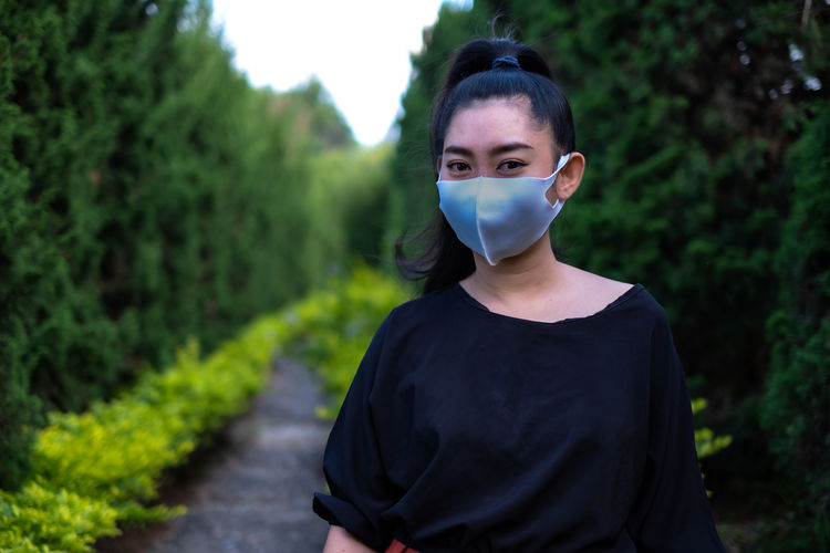 Young asia woman standing and put on a face mask