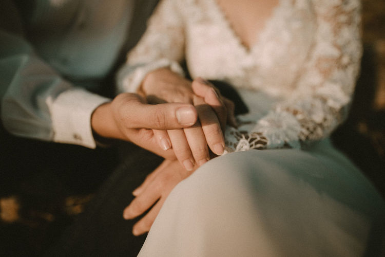 Midsection of couple holding hands