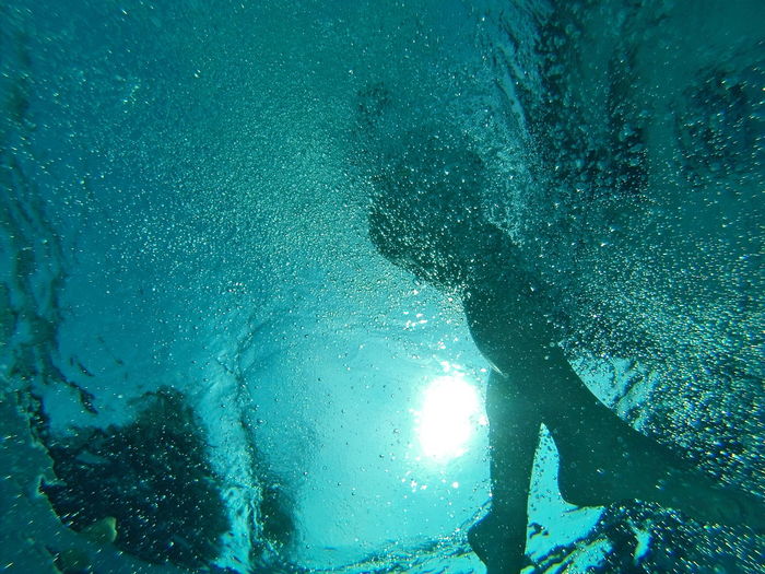 Woman swimming in turquoise pool