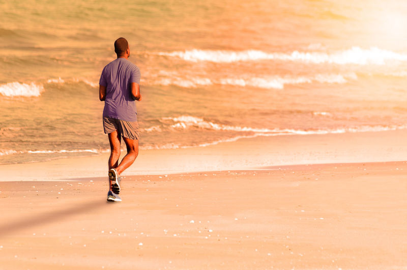Rear view of man standing on beach
