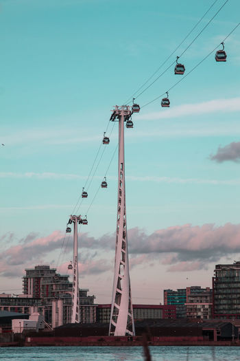 Low angle view of overhead cable car in city against sky