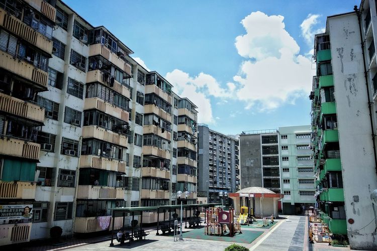 Road by buildings against sky in city