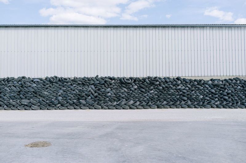 Stack of tyres piled up against wall