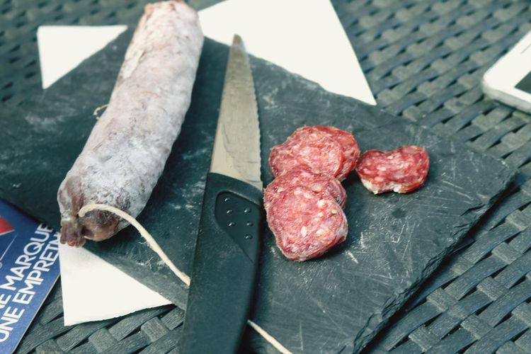 High angle view of salami with knife on cutting board
