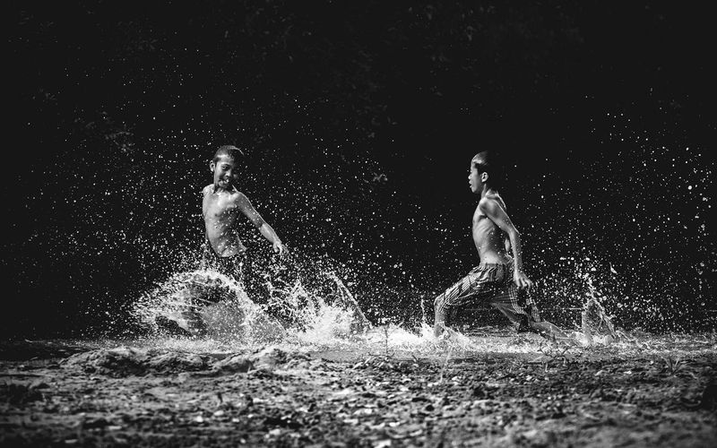 Boys playing in lake at night