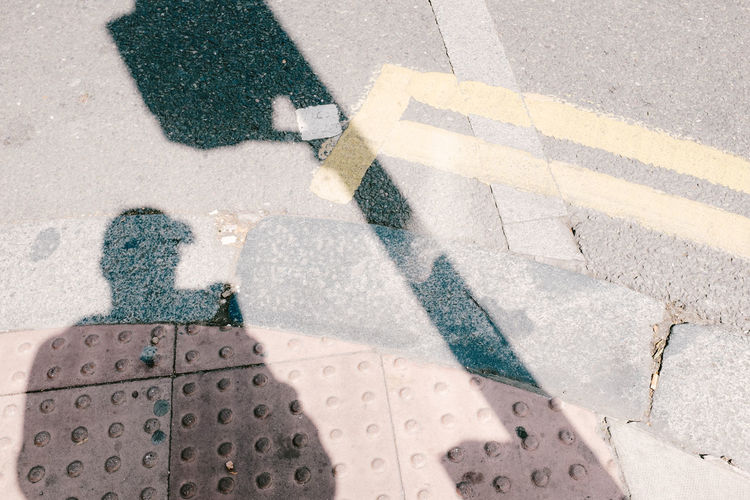 Shadow of man on sidewalk