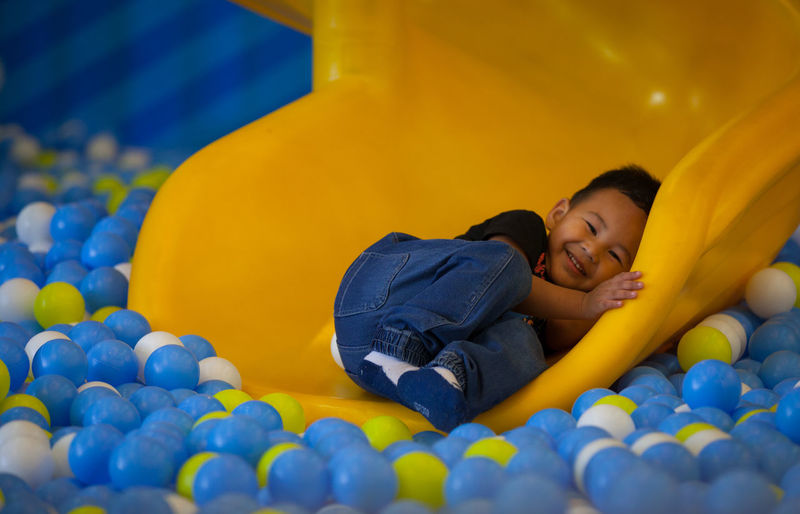 Portrait smiling boy playing in ball pool