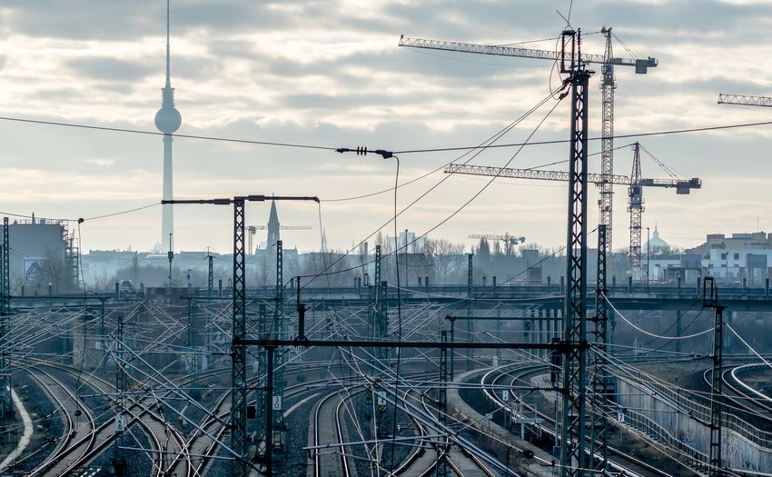High angle view of railroad tracks with fernsehturm in background against cloudy sky
