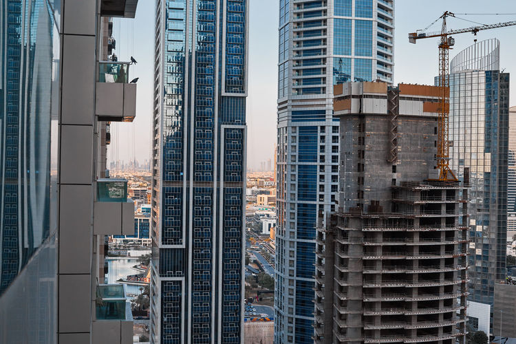 Construction of a new building in dubai against the backdrop of modern skyscrapers, travel