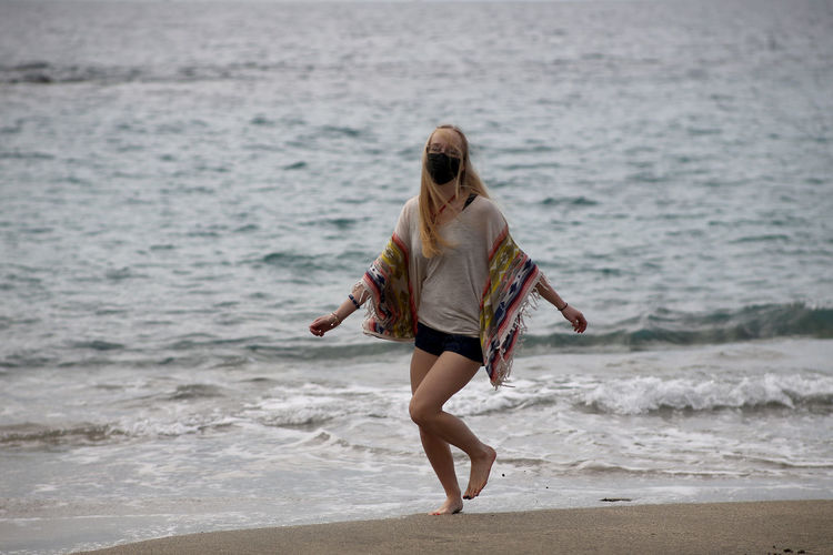 Portrait of young woman walking at beach