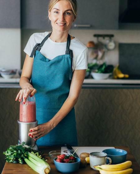 Mid adult woman preparing food on table at home