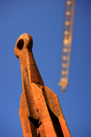 Low angle view of bird sculpture against blue sky