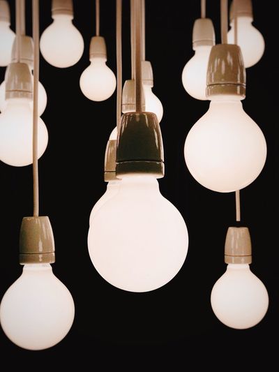 Close-up of illuminated light bulbs against black background
