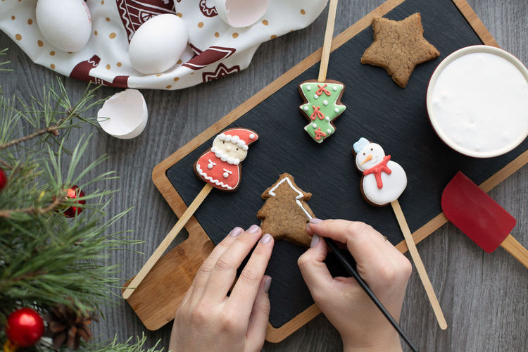 Flat lay with traditional christmas gingerbread. process of homemade decoration with female hands. 