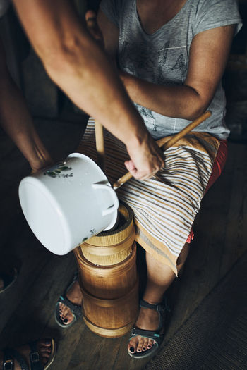 Woman making butter with butter churn. old traditional method making of butter