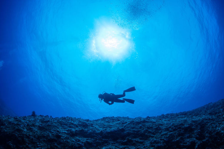 Silhouette person swimming in sea