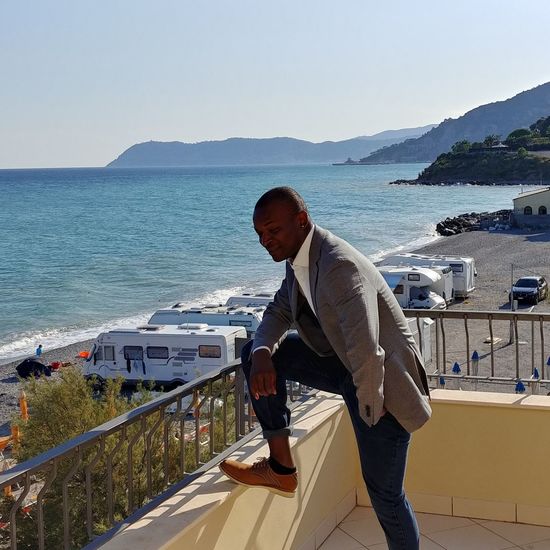 Side view of man looking at sea against clear sky