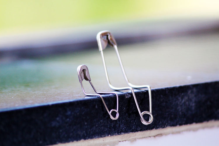 Close-up of safety pins on window sill