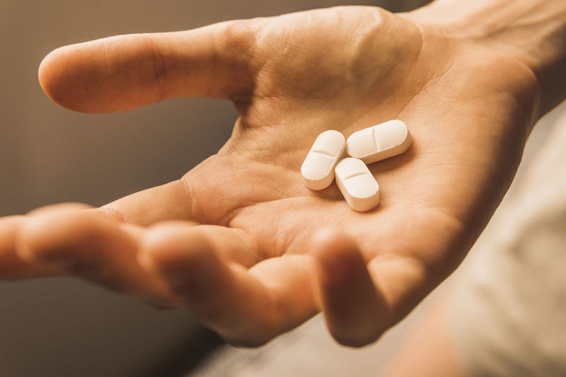 Cropped hand of person holding pills