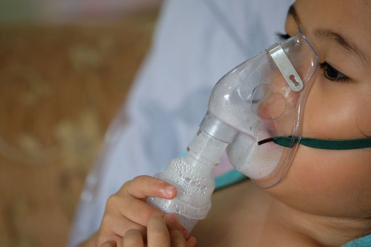 Close-up of girl wearing oxygen mask