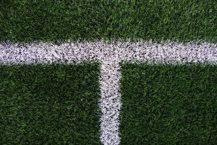 White line on green football field. artifical grass on winter soccer court. 