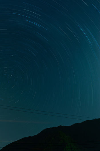 Low angle view of star trail against sky at night