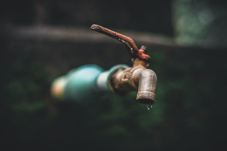 Close-up of water dripping from old rusty faucet