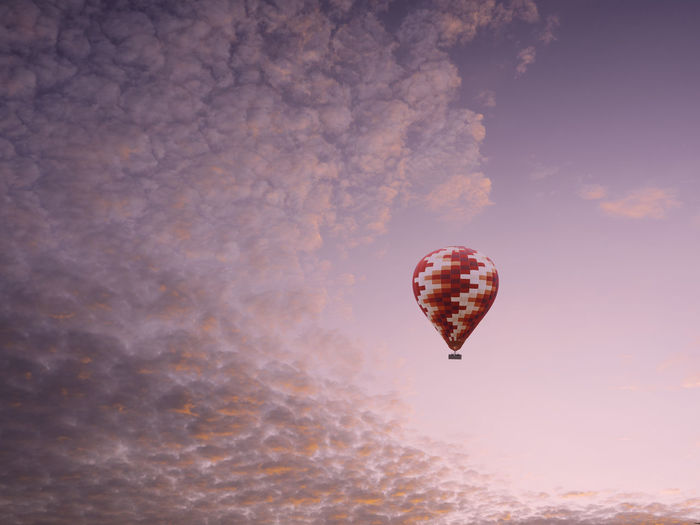 Digital composite image of hot air balloon flying against sky