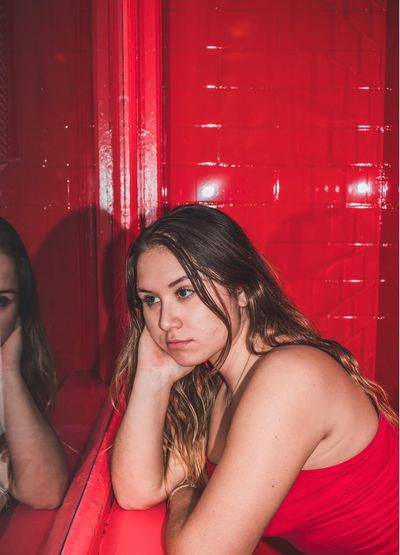 Thoughtful young woman sitting in red room