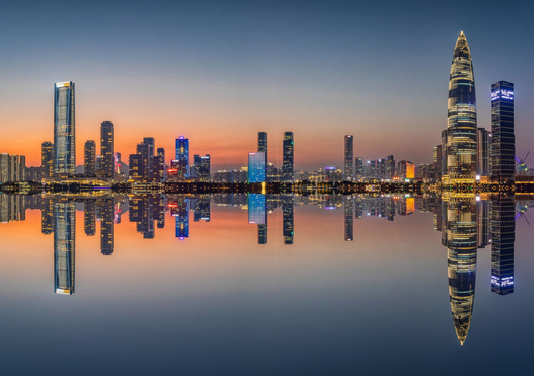 Illuminated buildings in city against sky