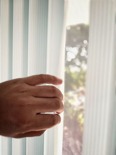 Cropped hand opening window blinds